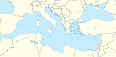 Mapa konturowa Morza Śródziemnego, blisko centrum na dole znajduje się punkt otoczony kołem zębatym z opisem „Cittadella”