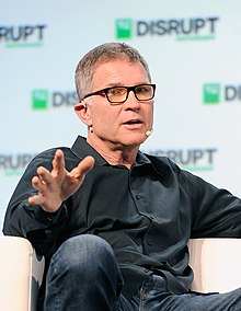 Photograph of David Baszucki speaking while sitting in a chair