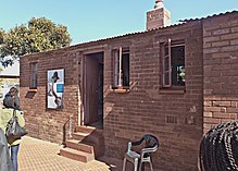 a ground-floor, red-brick building with a corrugated iron roof