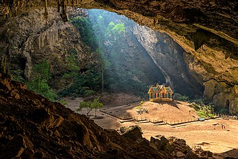 Pavilhão real na caverna Phraya Nakhon no Parque Nacional Khao Sam Roi Yot, província de Prachuap Khiri Khan, Tailândia. A caverna fica a cerca de 500 metros da praia de Laem Sala, aproximadamente 17 quilômetros ao norte da sede do parque. Os visitantes podem ir até a caverna alugando um barco ou caminhando pela montanha Tian. Depois disso, há uma subida de montanha de cerca de 430 metros para chegar à caverna. Ela tem uma abertura no teto que permite a penetração da luz do sol. O Pavilhão Khuha Kharuehat é um local histórico construído para a visita do rei Chulalongkorn à região em 1890. (definição 7 360 × 4 912)