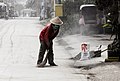 Man sweeping volcanic ash