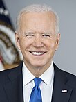 Biden standing with US flags behind him