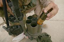 Photographie d'un soldat en train d'insérer des grenades de 40 mm dans le barillet d'un lance-grenades multiple.