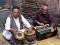 Sänger devotionaler Lieder mit Harmonium, begleitet von einem Tabla-Spieler vor einem hinduistischen Schrein in Kathmandu, Nepal