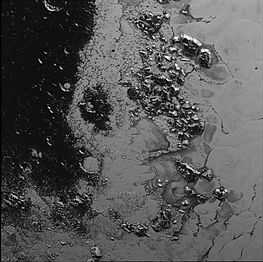 Esta imaxe amosa a rexión que está entre a "cabeza" de Cthulhu (esquerda) e a brillante Sputnik Planitia (dereita), cos Hillary Montes no centro.