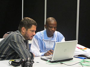 Simon Villeneuve at left helping a newcomer to make its first contributions to Wikipedia.