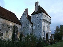 Photographie en couleurs d'une tour carrée portant des mâchicoulis.