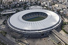 Vue aérienne du stade {{langue|pt|Maracanã}} couvert et de ses alentours avec les immeubles de la ville en arrière-plan.