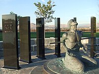 Statue of soldier bound on his knees surrounded by granite panels