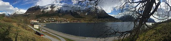 E39 gjennom Skei, administrasjonssentrum i Jølster kommune, ved Jølstravatnet. Foto: Fortegnet panoramabilde våren 2015