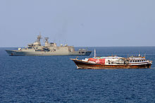 Aerial view of a frigate travelling at speed.