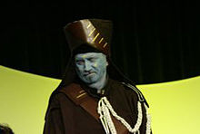 Homme portant un costume et maquillé en bleu.