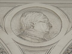 Bas-relief, la tête d'un homme de profil.