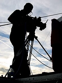 Man operating professional camera on tripod.jpg