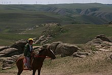 Un homme sur un cheval dans un paysage de collines