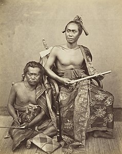 Raja Buleleng XIV, Gusti Ngurah Kĕtut Jĕlantik, bersama juru tulisnya, Wayan Tubok, sekitar tahun 1865. Keduanya sedang memegang lontar