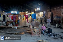 Shack housing within a larger building, children playing