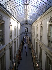 La galerie (en enfilade entre deux façades blanches) et sa verrière, vues du second étage.