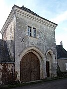 Photographie en couleurs d'une double porte en arc brisé percée dans une tour carrée.