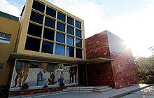 Photo of the front of the INCAP headquarters in Guatemala City, with a mosaic of people with different kinds of food