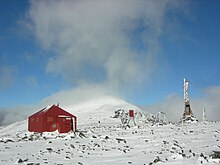 Photo de la station d'Axel Hamberg près du sommet de Pårtetjåkkå, constituée notamment d'une maison et d'une tour émettrice.