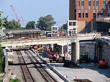 A light rail station under construction in a railway cut