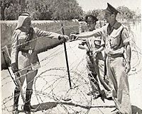 Israeli policemen meet a Jordanian Legionnaire near the Mandelbaum Gate (c. 1950)