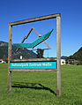 Schild des Zentrums mit Nationalpark-Logo: ein Steinadler vor Gebirgskulisse[5]