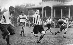 Scopelli jako hráč klubu Estudiantes skákající po centru spoluhráče Salvadora Férnandéze v utkání proti klubu Boca Juniors (1932)