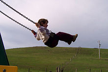 A boy on a playground swing.