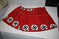 Fabric intended for swastika armbands brought home as an American soldier's personal World War II souvenir and made into a swimsuit in 1950 as an expression of disrespect. Exhibit on display in the North Carolina Museum of History.