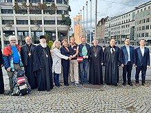 Vertreter von sieben Religionsgemeinschaften bei der Enthüllung der Friedenstaube vor dem Neuen Rathaus in Linz.