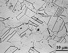 Znecitlivělá austenitická korozivzdorná ocel s patrnými karbidickými precipitovanými částicemi