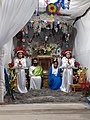 Representación de la Sagrada Familia. Dentro de la vitrina, la pequeña, antigua y venerada figura del niño Jesús.