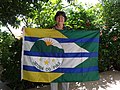 Bandeira de Jatobá do Piauí ostentada nas mãos da autora do desenho, pintora Avelina Rosa.