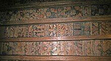 Four wooden beams with three sets of coloured paintings between them, made up of fruit, flowers and other patterns.