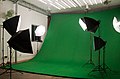 Photography studio with green screen backdrop.