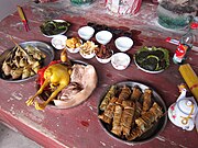 中国での祖先崇拝の例。食事のための食品類を、しかも酒類やお茶類まで用意して、祖先（の霊）に、供物としてささげている。