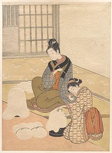 Barvni tisk dveh lepo oblečenih Japonk ob grelniku. Tapete in drugi predmeti so obsežno reliefni.
