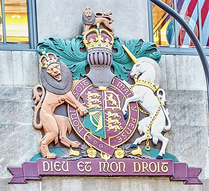 Polychromed limestone cartouche on the over-lintel of the British Empire Building that is part of Rockefeller Center, New York City. The cartouche was created by the artist Carl Paul Jennewein. It depicts the British Coat of Arms encircled with the gilded motto of the British chivalric Order of the Garter (and Frensh proverb): "Honi soit qui mal y pense" (Shame on him who thinks evil about it). The ottom of the bas relief is inscribed with the motto of the British Royalty: "Dieu et mon droit" (God and my right).