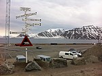 Avståndsskylt. I bakgrunden Adventfjorden mynning i Isfjorden, med Revneset till höger