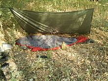 toile tendue au dessus d'un sac de couchage en montagne.