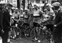 Photographie en noir et blanc montrant une équipe cycliste avant le départ d'une course.