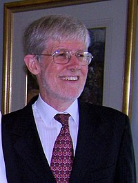 Man with white hair and beard wearing a suit