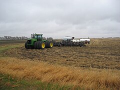 Tracteur articulé avec roues triplées. L'inconvénient par rapport aux chenilles réside dans la grande largeur hors-tout.