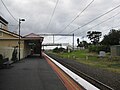 Southbound view from platform looking at station building and pedestrian bridge, April 2011