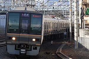 放出駅に入線する207系電車による普通列車（2024年1月）