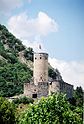 Photographie couleur d’un château en pierre, avec un donjon rond surmonté d’un drapeau