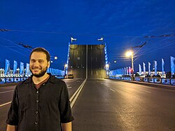 Man next to the Palace Bridge open at night