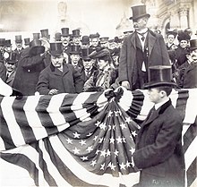 Roosevelt stands at the front of a crowd.